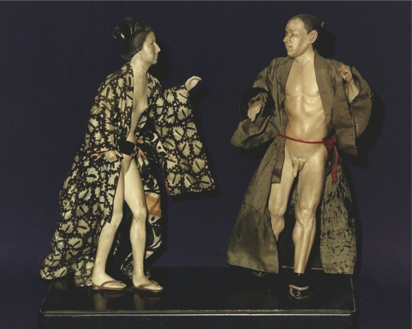 Een paar erotische figuren van pijpaarde, een man en een vrouw uitgebeeld als worstelaars in kimonodracht